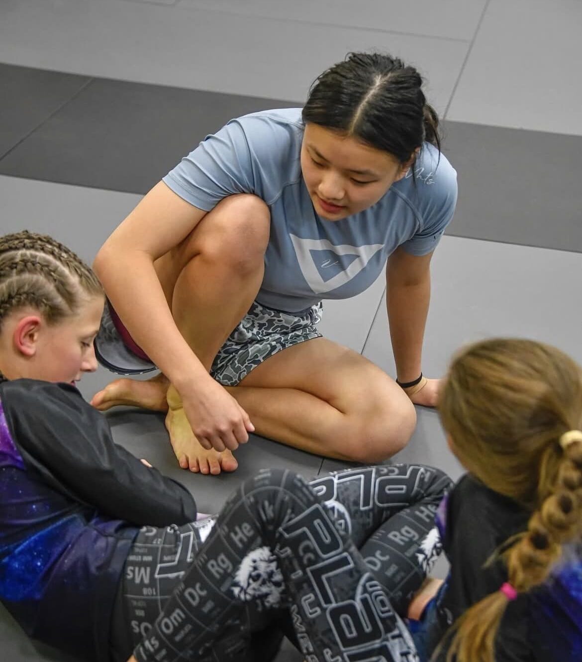 San Antonio young bjj students grappling with help of instructor.